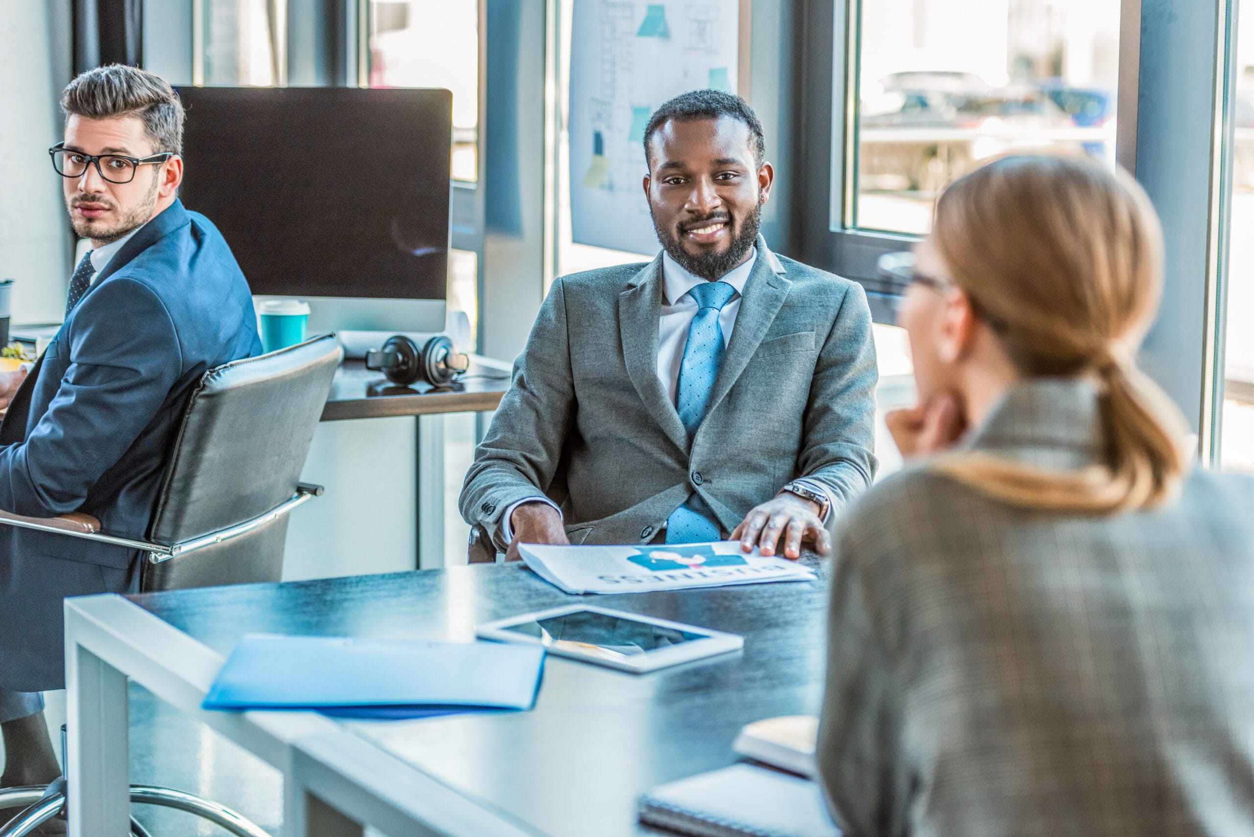 multicultural businesspeople talking at table in office multicultural businesspeople talking at table in office